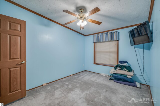 unfurnished room with ceiling fan, crown molding, light colored carpet, and a textured ceiling