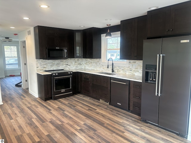 kitchen featuring tasteful backsplash, sink, wood-type flooring, and appliances with stainless steel finishes