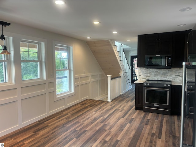 kitchen with electric stove, hanging light fixtures, dark hardwood / wood-style floors, decorative backsplash, and light stone counters