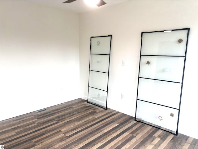 unfurnished bedroom featuring ceiling fan and dark hardwood / wood-style flooring