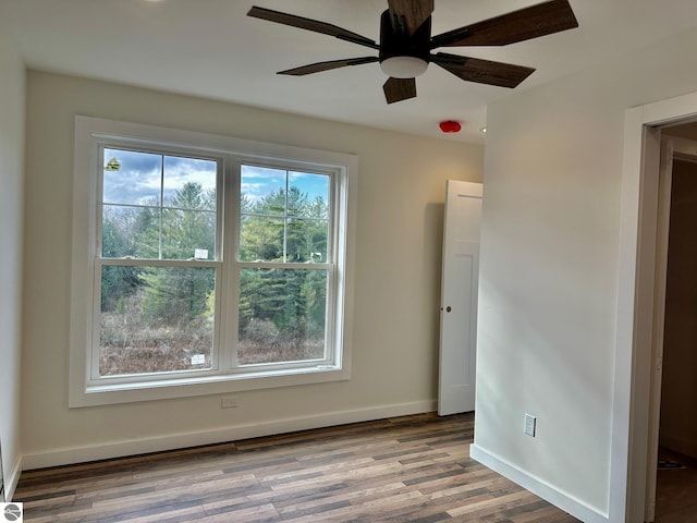 empty room with ceiling fan, a healthy amount of sunlight, and light hardwood / wood-style floors