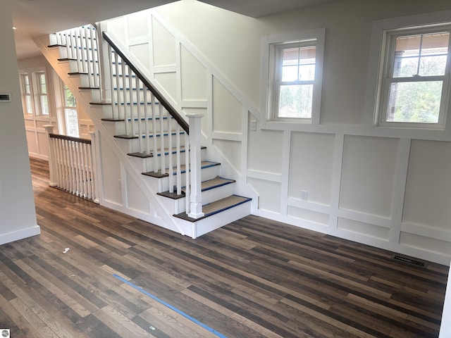 stairs featuring a healthy amount of sunlight and wood-type flooring