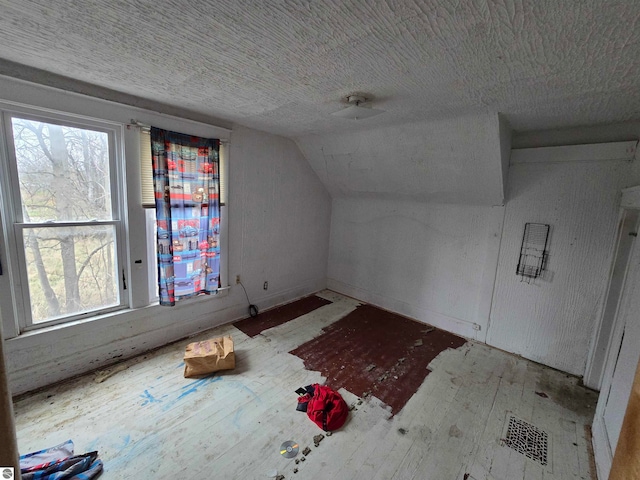 bonus room with light hardwood / wood-style floors and vaulted ceiling