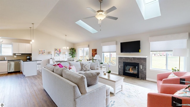 living room featuring lofted ceiling with skylight, plenty of natural light, and wood-type flooring