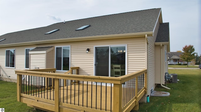 back of property with a lawn, central AC unit, and a wooden deck