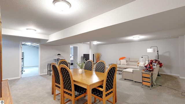 carpeted dining room featuring a textured ceiling