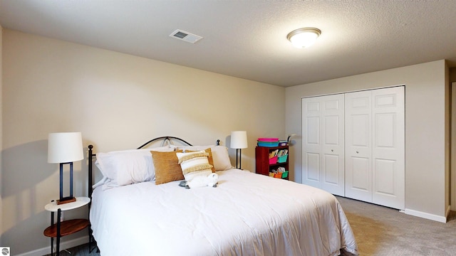 carpeted bedroom featuring a textured ceiling and a closet