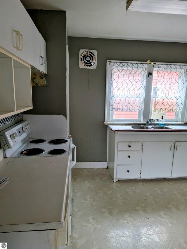 kitchen with white cabinets, white range with electric stovetop, and sink