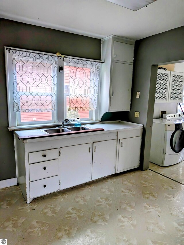 laundry room with a healthy amount of sunlight, sink, cabinets, and washer hookup