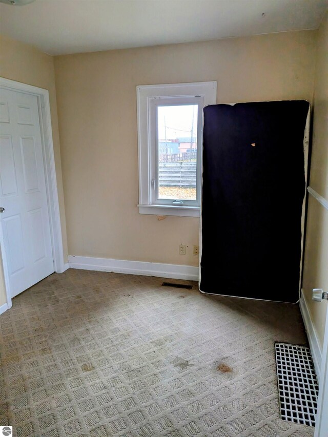 unfurnished room featuring light colored carpet