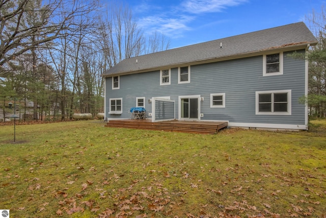 back of property featuring a deck and a lawn