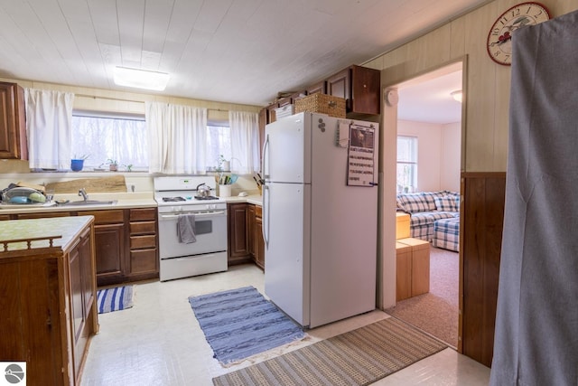 kitchen featuring white appliances, wooden walls, sink, tile countertops, and wooden ceiling