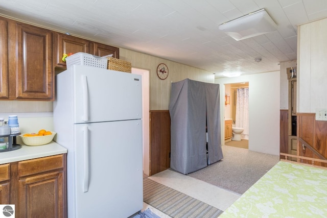 kitchen with white fridge and wood walls