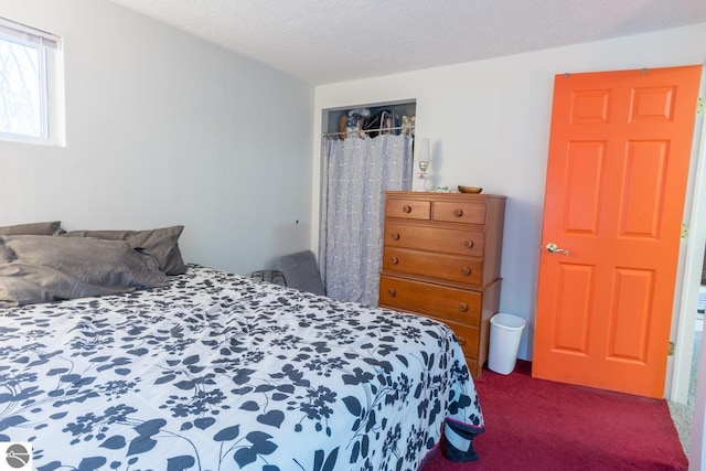 carpeted bedroom featuring a textured ceiling and a closet