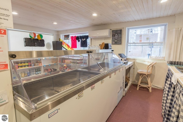 kitchen with white cabinetry, dark carpet, a wall mounted AC, and stainless steel counters