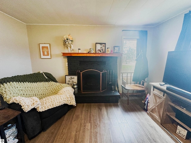 sitting room featuring hardwood / wood-style floors and a brick fireplace