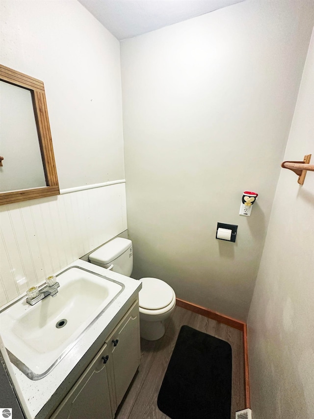 bathroom with vanity, toilet, and hardwood / wood-style floors