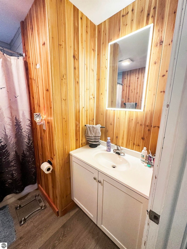 bathroom featuring vanity, hardwood / wood-style floors, and wood walls