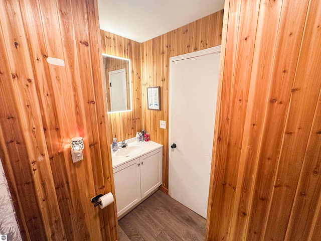 bathroom featuring vanity, wood-type flooring, and wooden walls