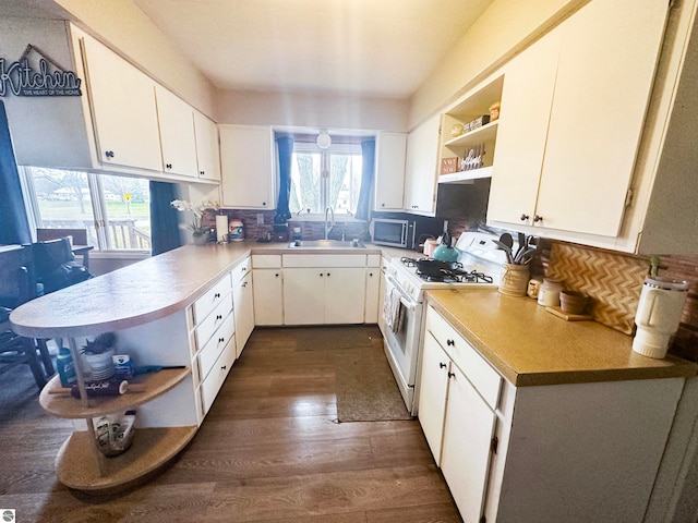 kitchen with sink, white cabinetry, dark hardwood / wood-style floors, tasteful backsplash, and white gas stove