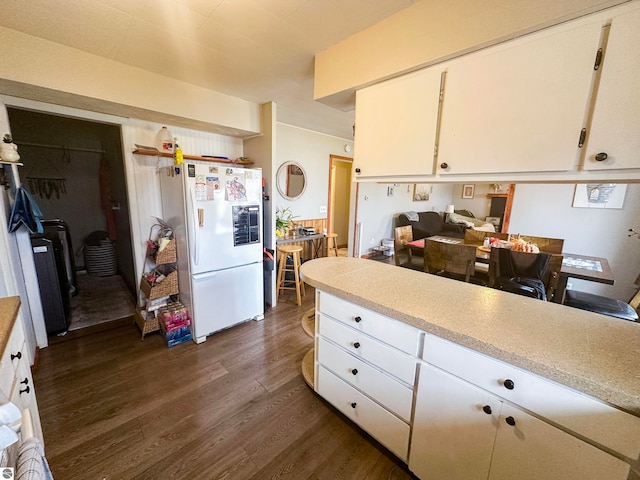 kitchen featuring white refrigerator, dark hardwood / wood-style flooring, and white cabinets