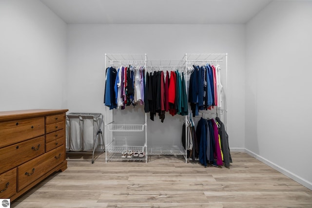 walk in closet with light hardwood / wood-style floors