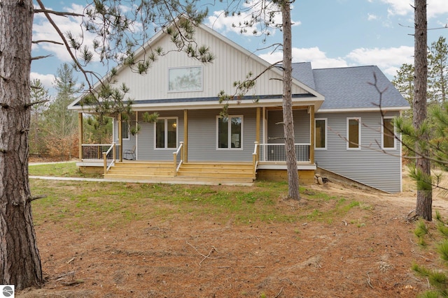 back of property featuring covered porch and a lawn