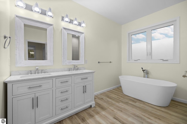 bathroom featuring hardwood / wood-style floors, vanity, and a tub to relax in