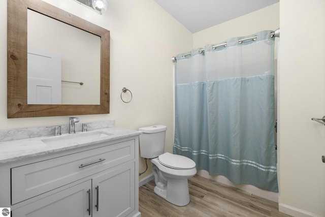 bathroom featuring wood-type flooring, vanity, toilet, and walk in shower