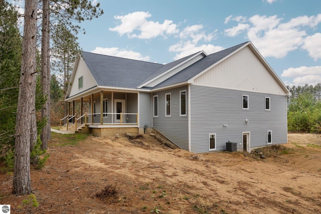 view of side of property featuring a porch and cooling unit