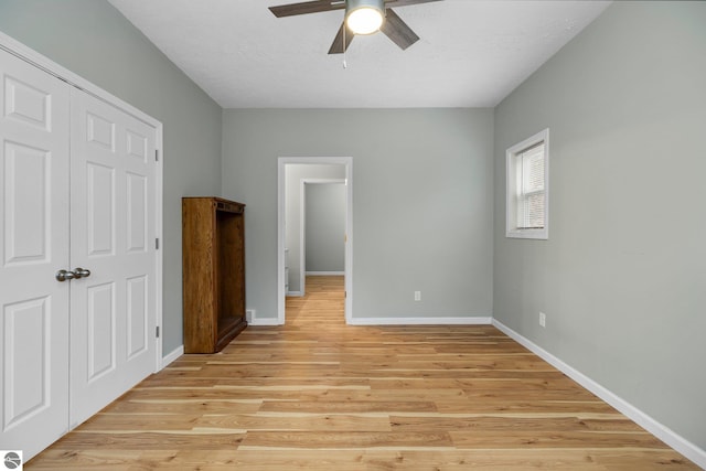 unfurnished bedroom with ceiling fan, a closet, and light hardwood / wood-style flooring