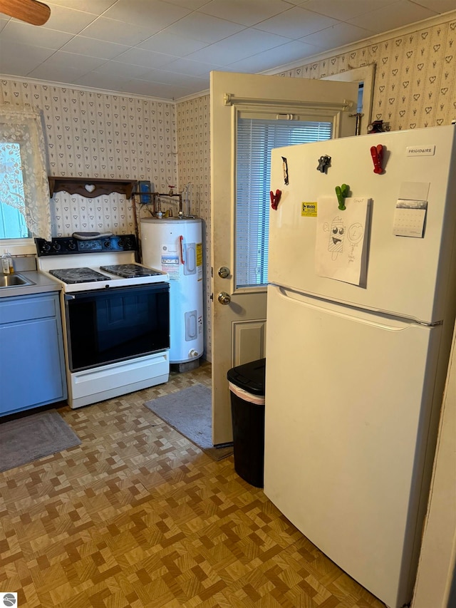 kitchen featuring sink, white appliances, electric water heater, and light parquet flooring