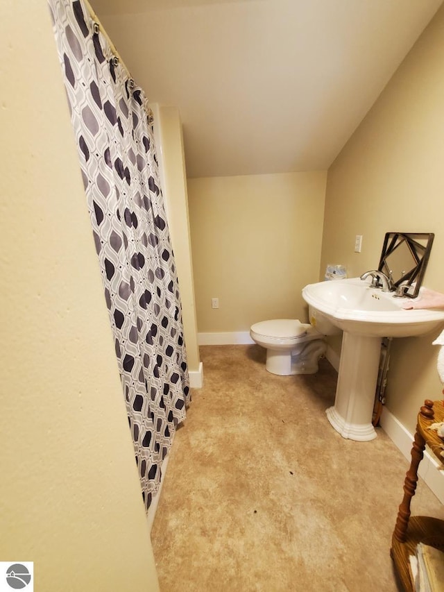 bathroom featuring toilet and curtained shower