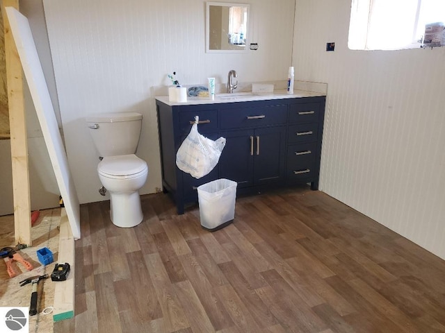 bathroom featuring hardwood / wood-style flooring, vanity, toilet, and a wealth of natural light