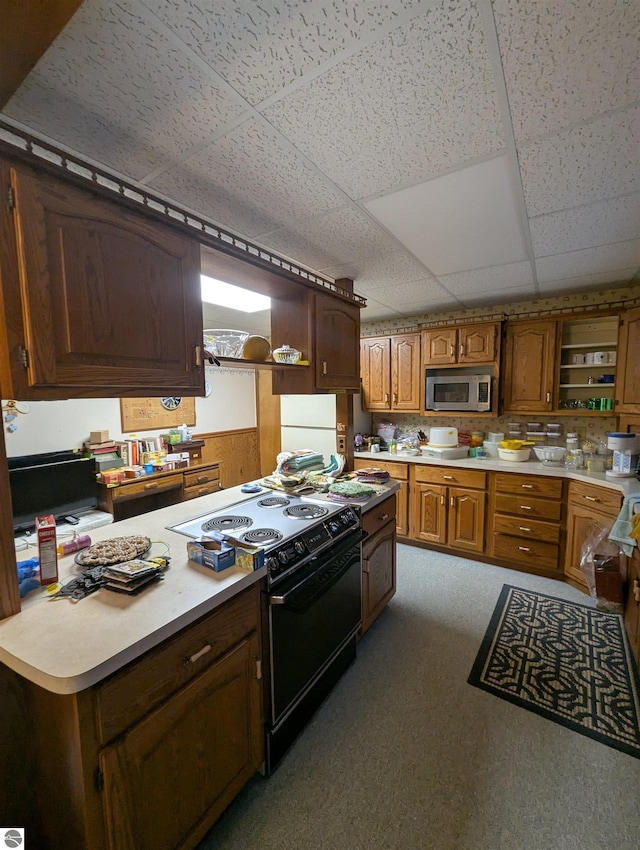 kitchen featuring a paneled ceiling, white fridge, and black / electric stove