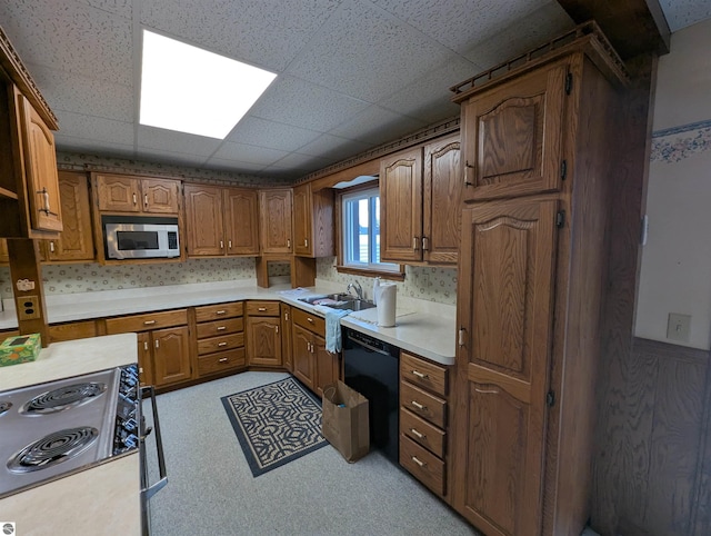 kitchen featuring a drop ceiling, sink, and appliances with stainless steel finishes