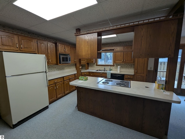 kitchen with a drop ceiling, sink, tasteful backsplash, kitchen peninsula, and stainless steel appliances