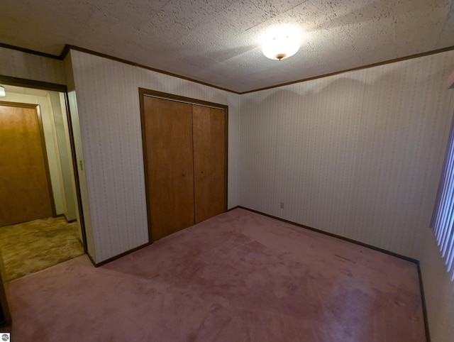 unfurnished bedroom with a closet, carpet, and a textured ceiling