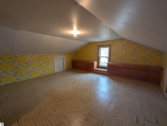 bonus room with light parquet floors and lofted ceiling