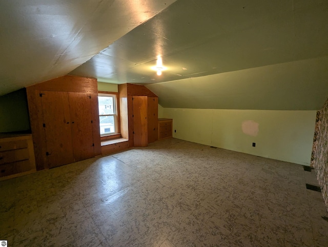 additional living space featuring lofted ceiling