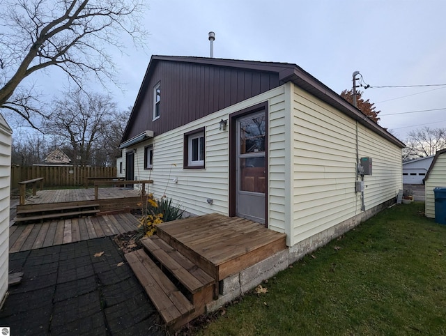 back of property with a lawn and a wooden deck