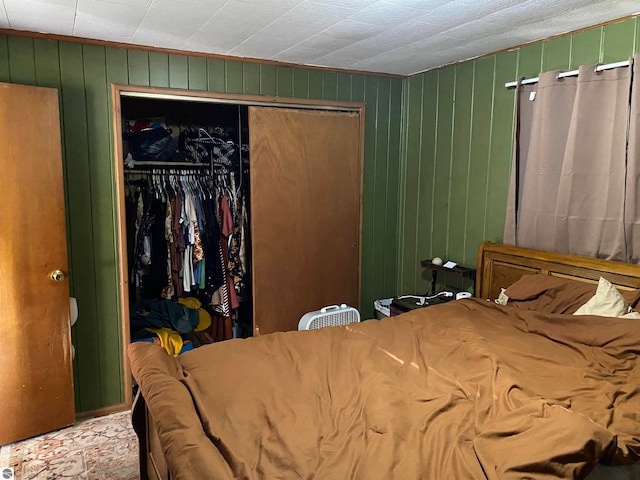 bedroom featuring wooden walls and a closet