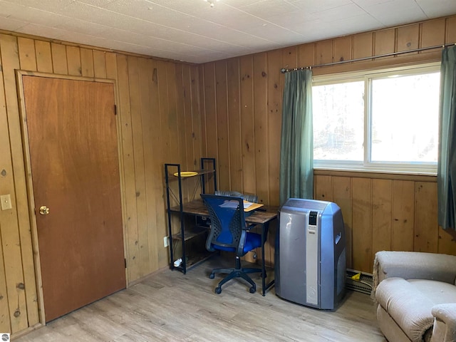 office area featuring light wood-type flooring and wooden walls