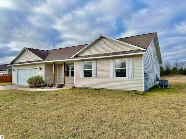 view of front of house with central AC, a front yard, and a garage