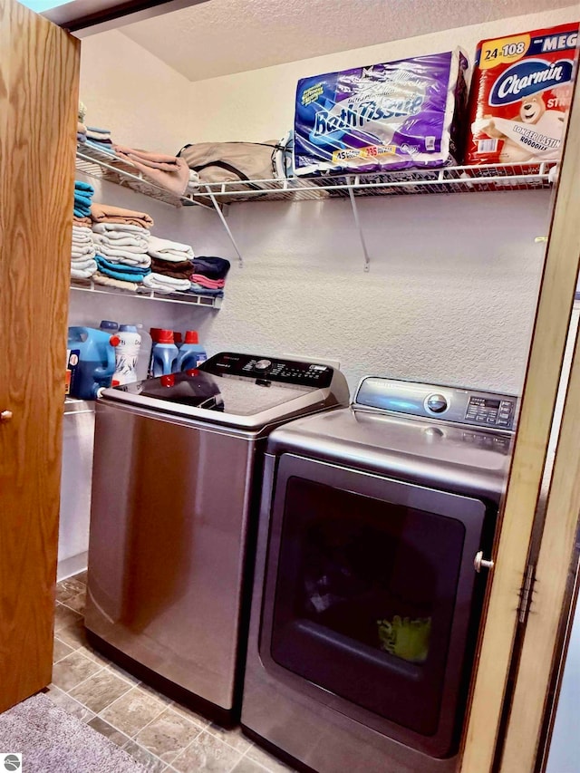 laundry room with a textured ceiling, separate washer and dryer, and light tile patterned flooring