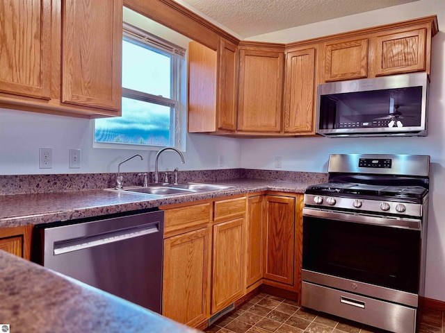 kitchen featuring sink, stainless steel appliances, and a textured ceiling