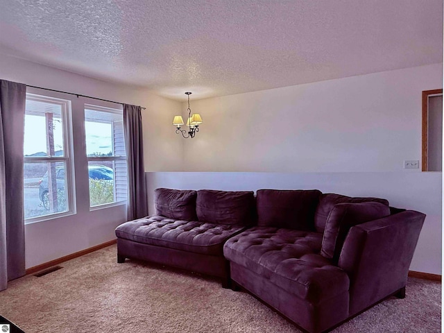 living room with a notable chandelier, carpet floors, and a textured ceiling