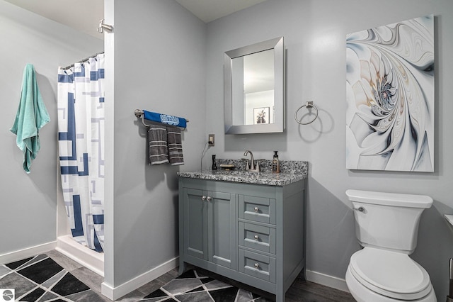 bathroom featuring curtained shower, vanity, hardwood / wood-style flooring, and toilet