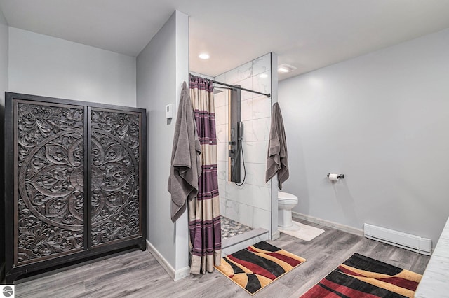 bathroom with hardwood / wood-style flooring, toilet, baseboard heating, and walk in shower