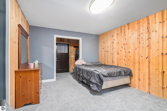 bedroom featuring carpet flooring and wood walls